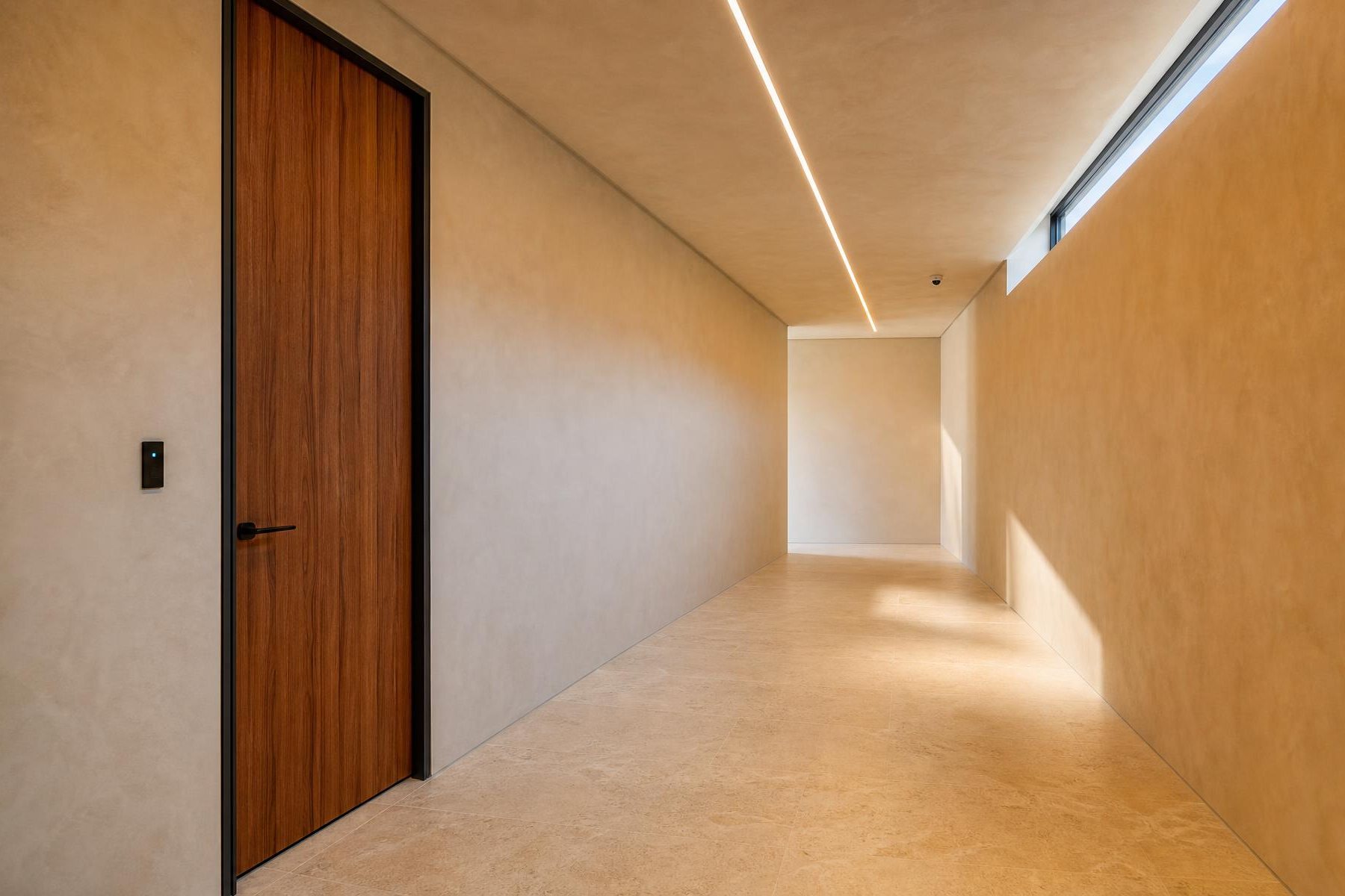 A discreet credential reader beside an interior door.